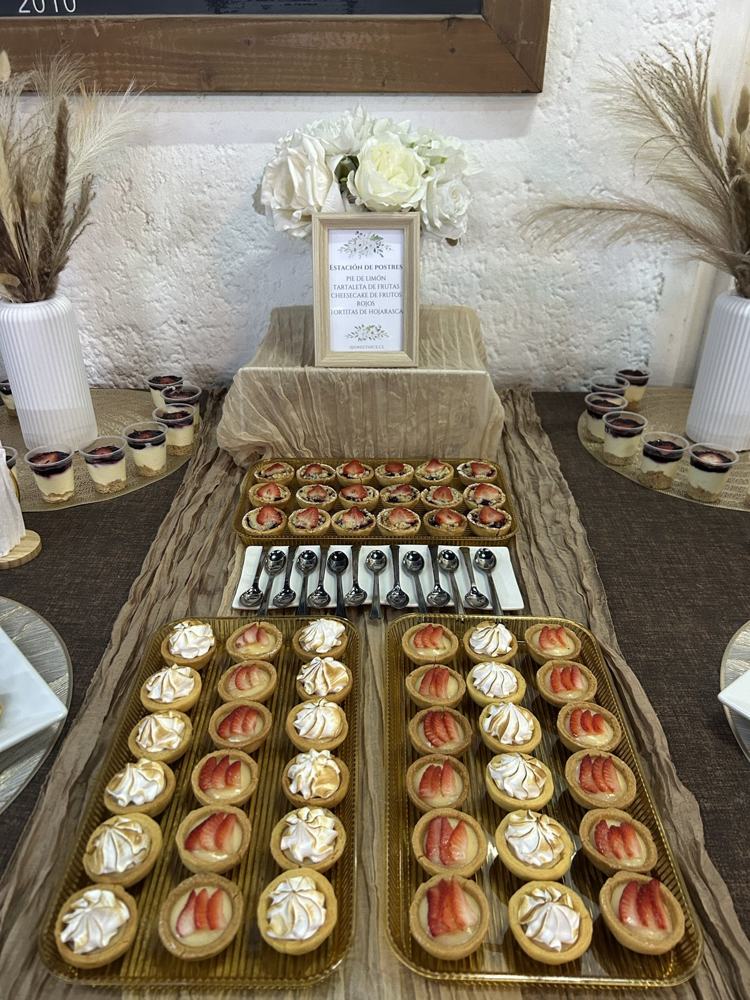 Mesa de celebración con tartaletas, cachitos y pasteles